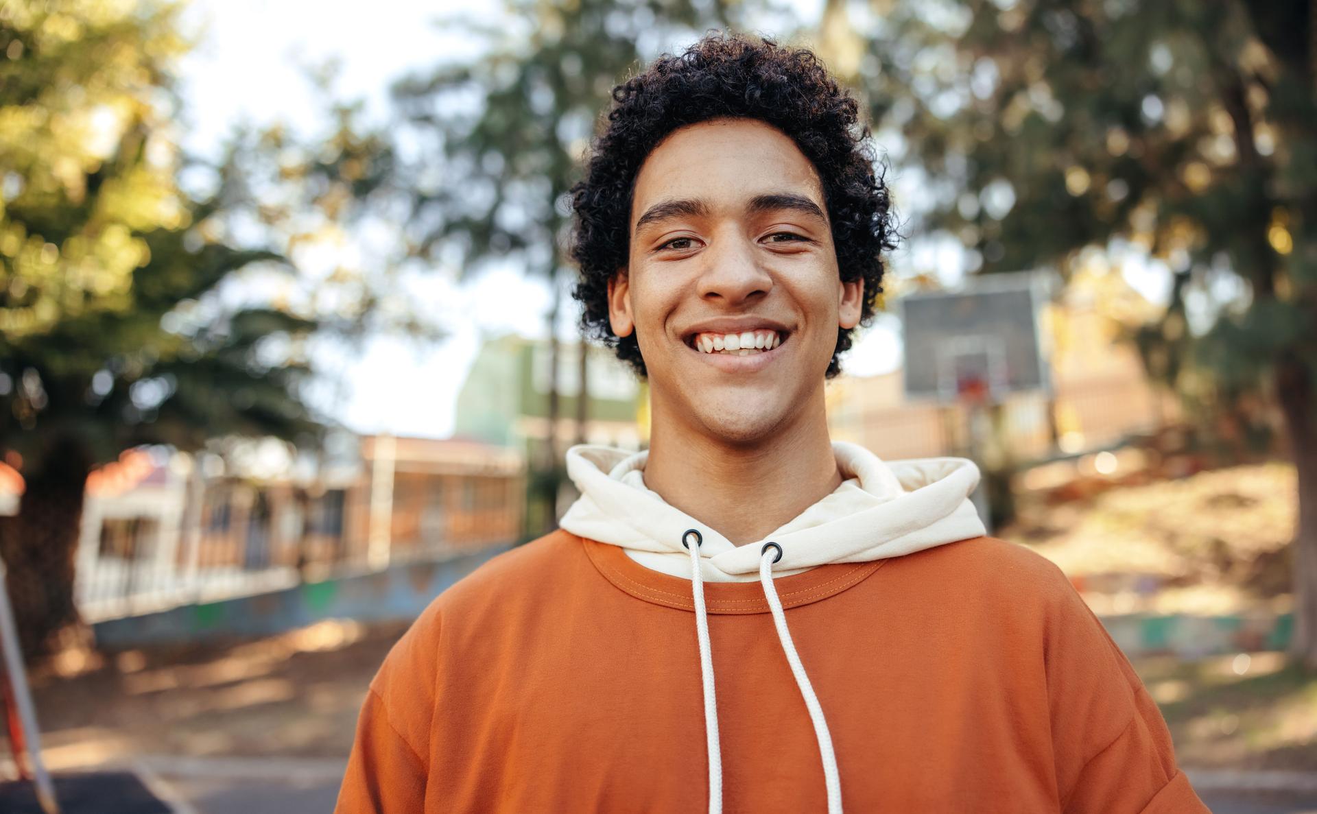 Happy male youngster smiling at the camera outdoors