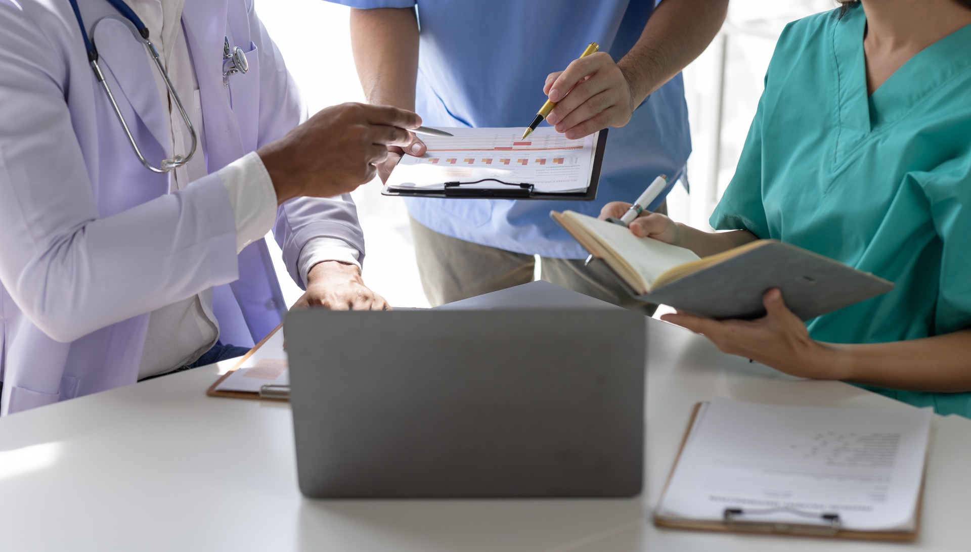 Medical, meeting and healthcare workers for team in office, discussion, brainstorming and planning. Doctor, nurse and computer on desk show diversity in collaboration or workshop for data analytics